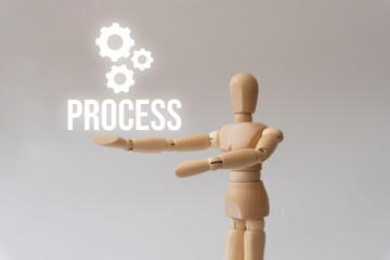 A wooden figure is holding a sign that says 