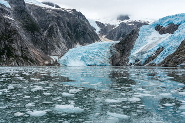 Blue Ice Glacier and Floating Ice in Kenai Fjords National Park, Alaska; Blue ice of Northwestern Glacier in Kenai Fjords National Park, Alaska, reflecting in the ocean with floating glacial ice