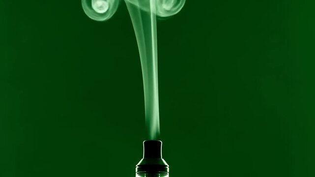 Elegant Green Vapor Swirls from Vape Device Against Green Background