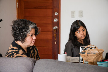 Mother and daughter are sitting at a table, one of them is wearing a striped shirt