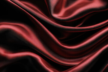 Fototapeta premium Satin red fabric on a black background. Abstract design 
