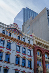 Fototapeta premium Detailed Facades of Classic Buildings Stand Tall Beneath Towering Glass and Concrete Modern City Structures