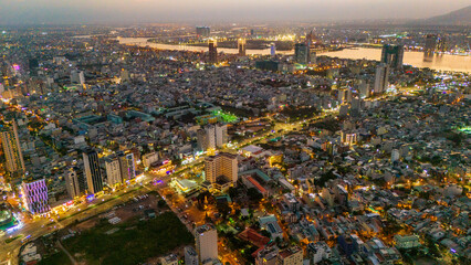 Obraz premium Aerial drone panorama of Da Nang city center split by the Han River. Massive urban skyline featuring iconic bridges connecting the modern metropolis in Vietnam