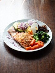 healthy dish of grilled salmon with boiled egg, blanched carrot, spinach and ear mushroom and fresh shallot and avocado