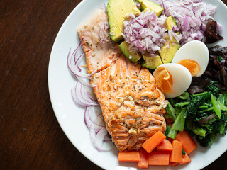 healthy dish of salmon steak with boiled egg, blanched carrot, spinach and ear mushroom and fresh shallot and avocado