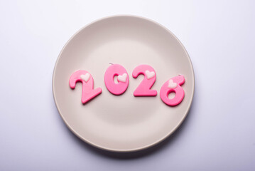 Pink 2026 number on the plate. New Year concept. Flat lay. Nobody.