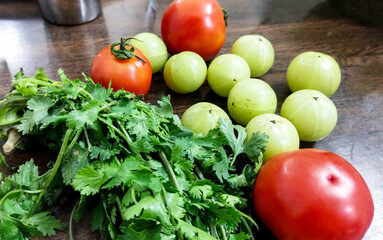 Fresh Amla, Tomatoes and Coriander on Wooden Table. Healthy Indian Ingredients