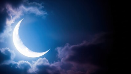 Crescent moon shining brightly in the night sky, surrounded by soft, fluffy clouds.