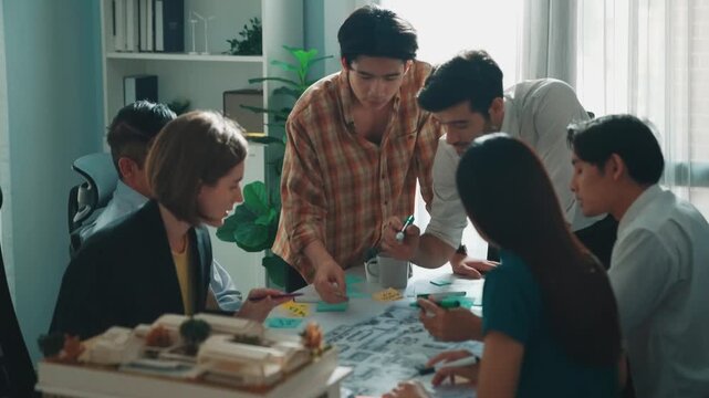 Group of diverse team planning strategy while sitting at table with project plan. Top aerial view of smart business people working together to brainstorm and design house construction. Alimentation.