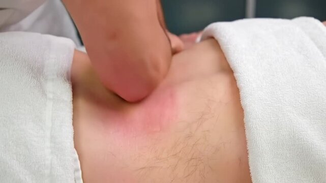 Masseur Using Elbow to Perform Deep Visceral Abdominal Massage on Patient Lying on Table - Therapeutic Bodywork