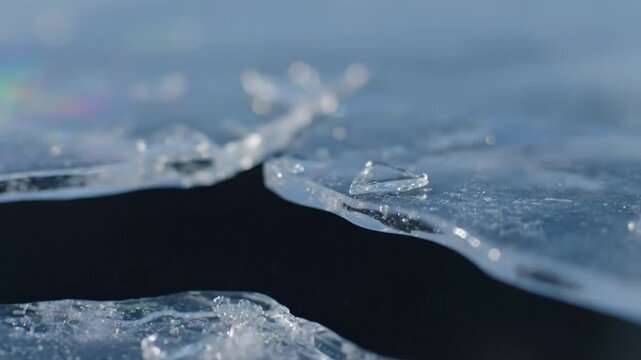 Close up of ice cracking and breaking apart in slow motion.