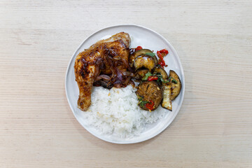 A plate of grilled chicken and eggplant with white rice.