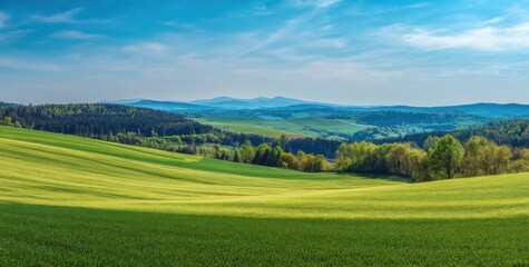 Fototapeta premium Beautiful landscape with green fields and forests under blue sky. Summer nature scenery with mountains and hills.