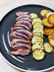 Slices of duck breast meat and zucchini.