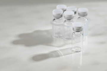 Close up of Empty Glass Vials with One Filled with Lyophilized Substance 