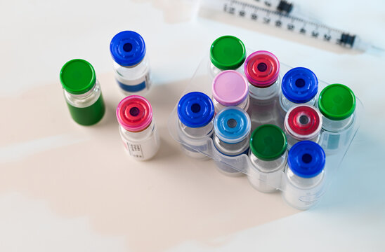 Assortment of Glass Vials with Various Color Tops and Labels