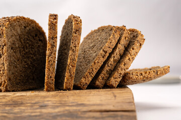 dark full grain bread in white background with blur