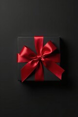 A dark square gift box adorned with a vibrant crimson ribbon bow, a symbol of thoughtful presentation and celebratory gifting