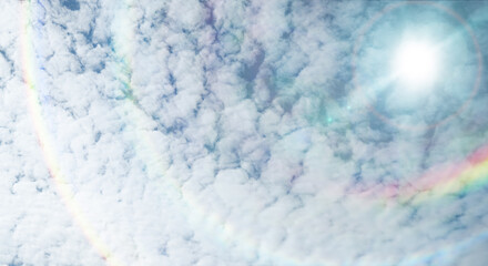 夏の晴天、青空に流れる積乱雲ふわふわの入道雲とギラギラ輝く太陽とレンズフレアとゴーストの背景壁紙　夏・夏休み・行楽・バカンス・アウトドア・キャンプ・天気・台風一過・季節