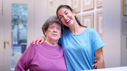 Fototapeta premium Granddaughter embracing grandmother, showing family support and care