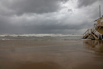 Winter storm Byron on the Mediterranean coast of Tel Aviv. A lifeguard station and waves crashing on a sandy beach