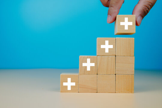 Positive things; added value, benefits, additional, personal development, growth mindset, positive thinking, opportunities, emerging market. Putting the cubes with plus sign to offer positive things.