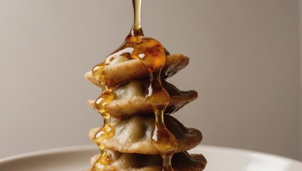 Sweet golden syrup pouring over a delicious stack of mini waffles.