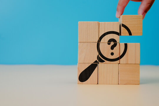Problems and root cause analysis concept. Define problems to find solution. The wooden cubes with illustration magnifying glass to analyze question mark sign on blue background and copy space.