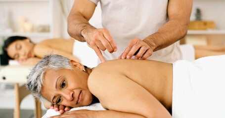 Acupuncture, mature woman and relax in spa with needle for back pain, wellness or traditional...