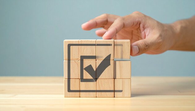 Hand Completing Grid of Checkmark Wooden Blocks  Quality Control, Compliance, and Standard Verification