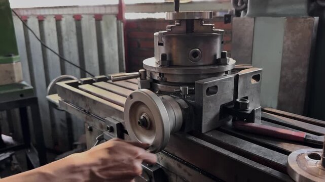 Skilled craftsmen precisely adjust industrial milling machine components in the workshop.