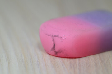 Close up of used pink and purple eraser on wood