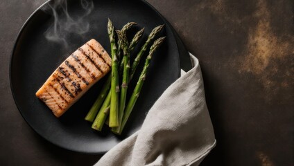 Grilled salmon fillet with asparagus on a dark plate, steam rising