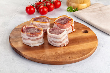 Raw pork tenferloin with bacon