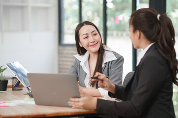 Asian businesswoman at work using laptop talking and consulting in office	