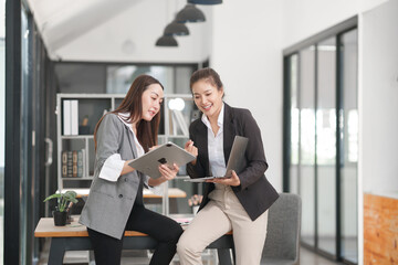 Asian businesswoman sitting at work using laptop talking and consulting in office