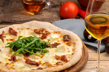 pizza with pineapple and chicken on a board on the table