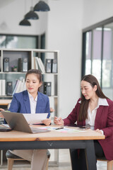 Asian businesswoman at work using laptop talking and consulting in office	