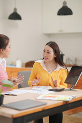Asian businesswoman sitting at work using laptop talking and consulting in office