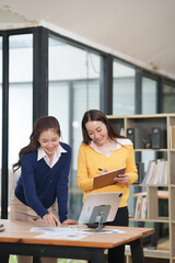 Asian businesswoman at work using laptop talking and consulting in office	