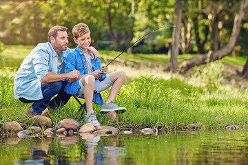 Dad, happy and fishing with son, river or teaching boy with rod on summer vacation, tips and outdoor. Holiday, man and child with equipment to catch fish, learning and skill development in nature
