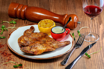 Roasted Tabaka chicken in a plate on the table with wine and spices