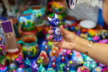 Decorative Ceramic Cat Figurine Held in Hand at a Market Stall
