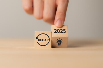 Naklejka na ściany i meble 2025 Recap economy, business, financial concept. Business planning in 2026. RECAP text on wooden blocks and hand flipping of 2025 to strategic planning and idea icon on wooden blocks.