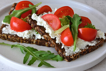 Healthy Breakfast Toast with wholegrain bread and Cottage Cheese, cherry Tomatoes and Arugula