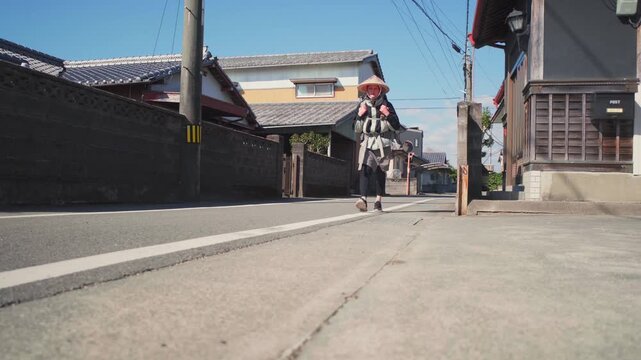 Girl Henro walks the route of 88 temples on Shikoku Island through the forest