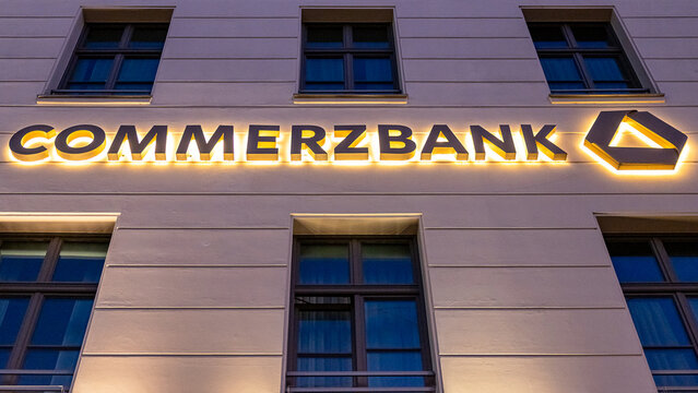 Beleuchteter Schriftzug der Commerzbank an der Fassade eines Gesch&auml;ftsgeb&auml;udes in der M&uuml;nchner Innenstadt.