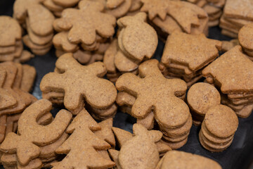 Baked gingerbread cookies lying on top of each other side by side.
