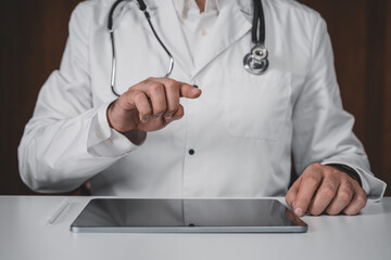 Doctor interacting with digital tablet using hand gestures in modern telemedicine concept on clean background for future healthcare technology application.