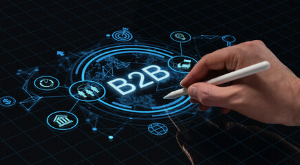Hand using stylus to interact with futuristic B2B holographic interface on digital screen background illustrating tech business concept..